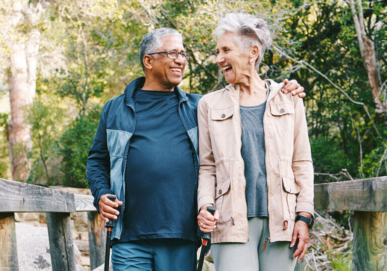 Happy senior couple walking outside in nature.