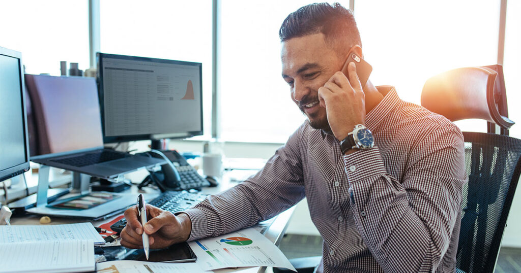 Outsourced accountant on phone with client discussing financials