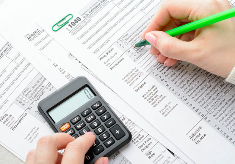 A woman sitting at a table and fills the tax form
