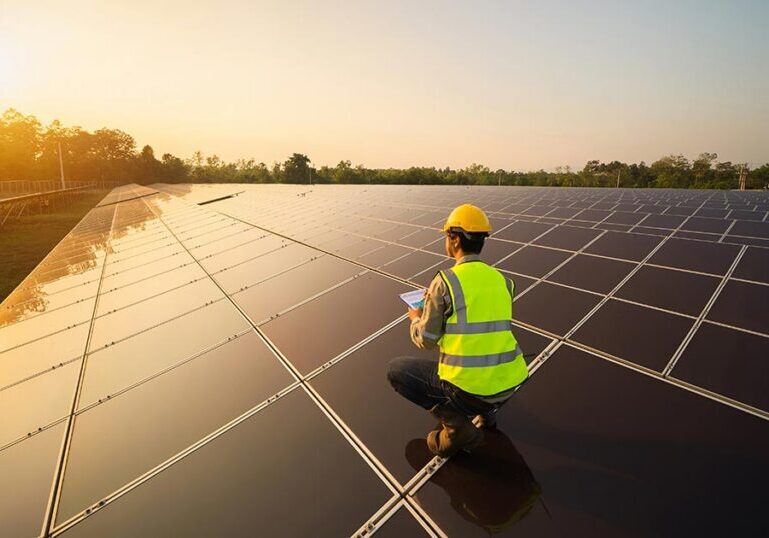 Impact investing professional evaluating a large solar energy project at sunrise, symbolizing sustainable finance and positive environmental change