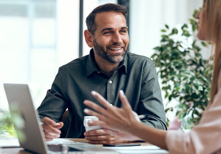 Business leader discussing artificial intelligence strategy with colleague during meeting about AI disillusionment