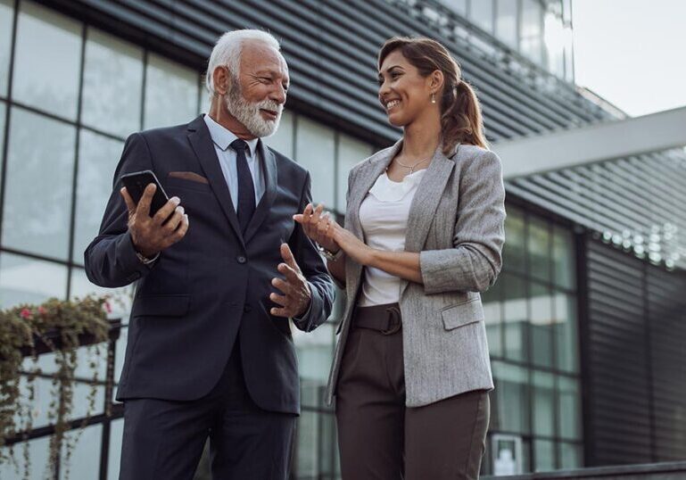 Financial advisor and client discussing real estate tax strategy outside a modern office building