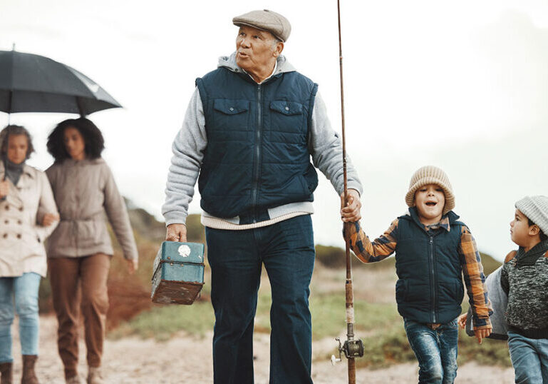 Multigenerational family walking together on a beach for a fishing trip, representing how thoughtful family wealth planning can create shared experiences and lasting memories across generations