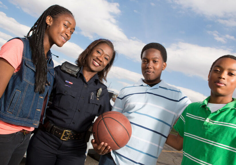 EMERGENCY SERVICES - Policeman talking to kids on the street